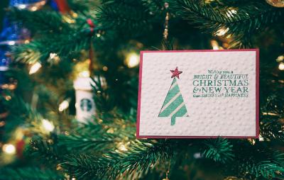 Cartolina di Natale che appende su un albero